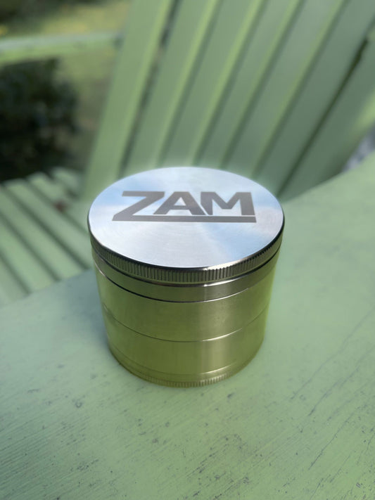 Big stainless steel zam grinder sitting on a green chair