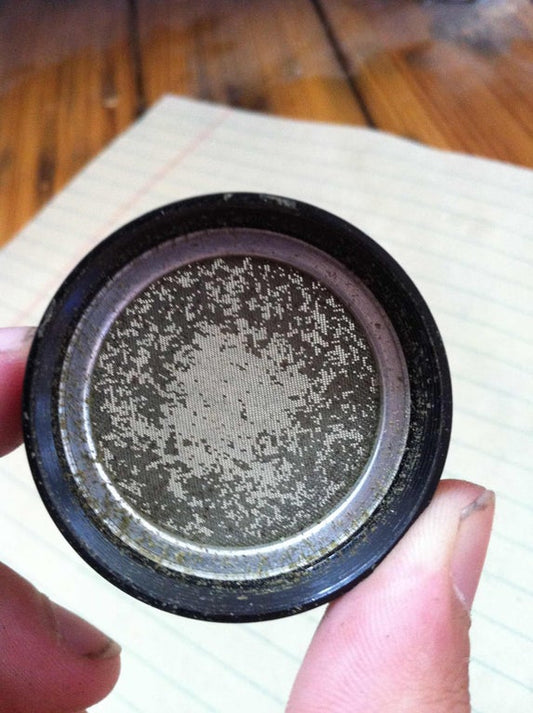 A clogged herb grinder's screen