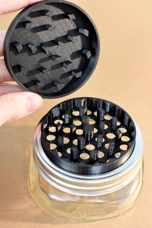 a weed grinder with a glass jar underneath it