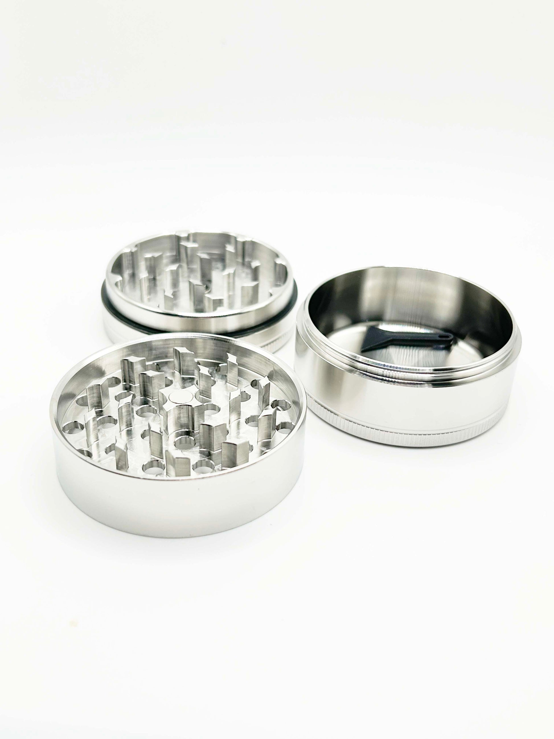 different sections of the grinder laid out. The two sections with teeth, and then a third deep container. No screen shown. 