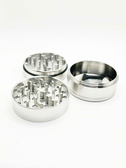different sections of the grinder laid out. The two sections with teeth, and then a third deep container. No screen shown. 