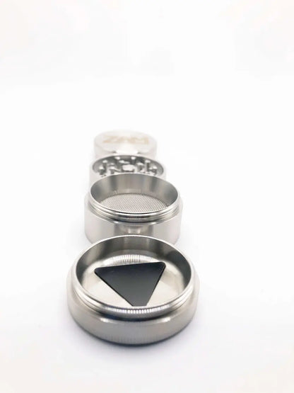 Small steel herb grinder with a deep curved pollen tray. Main storage has a screen.