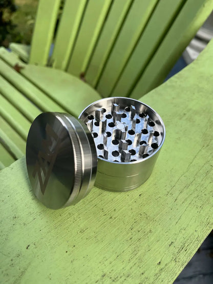 Grinder's lid is off. Curved diamond teeth and uniform circular holes. Central magnet