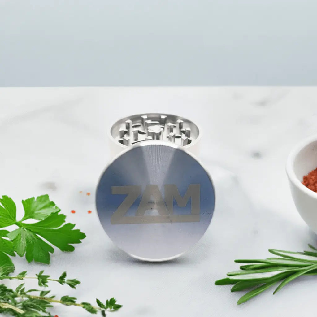 stainless steel herb grinder sitting on a kitchen countertop